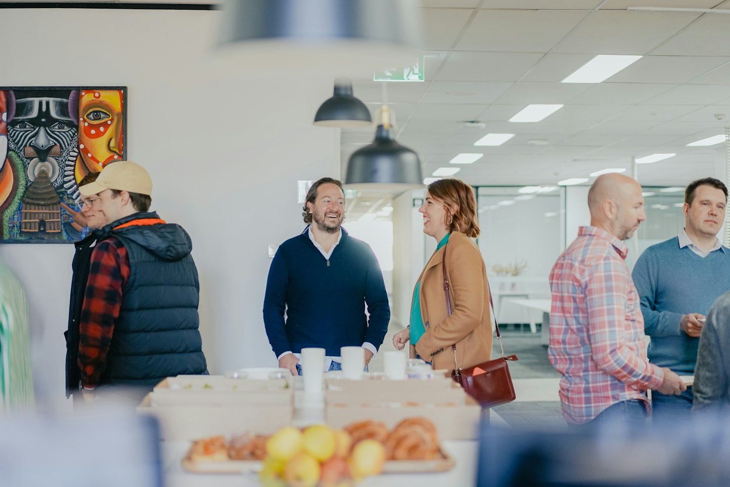 Business people laughing and conversing at a corporate event.