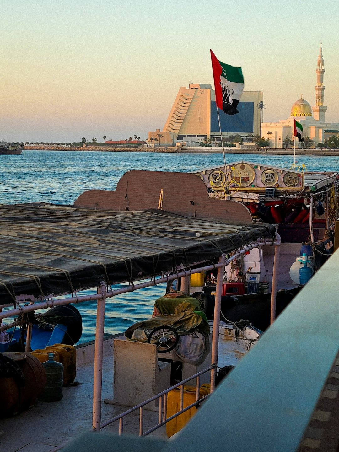 A traditional wooden boat with a UAE flag sits on the water.