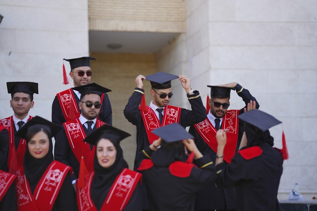 Graduates in caps and gowns standing outside a building.
